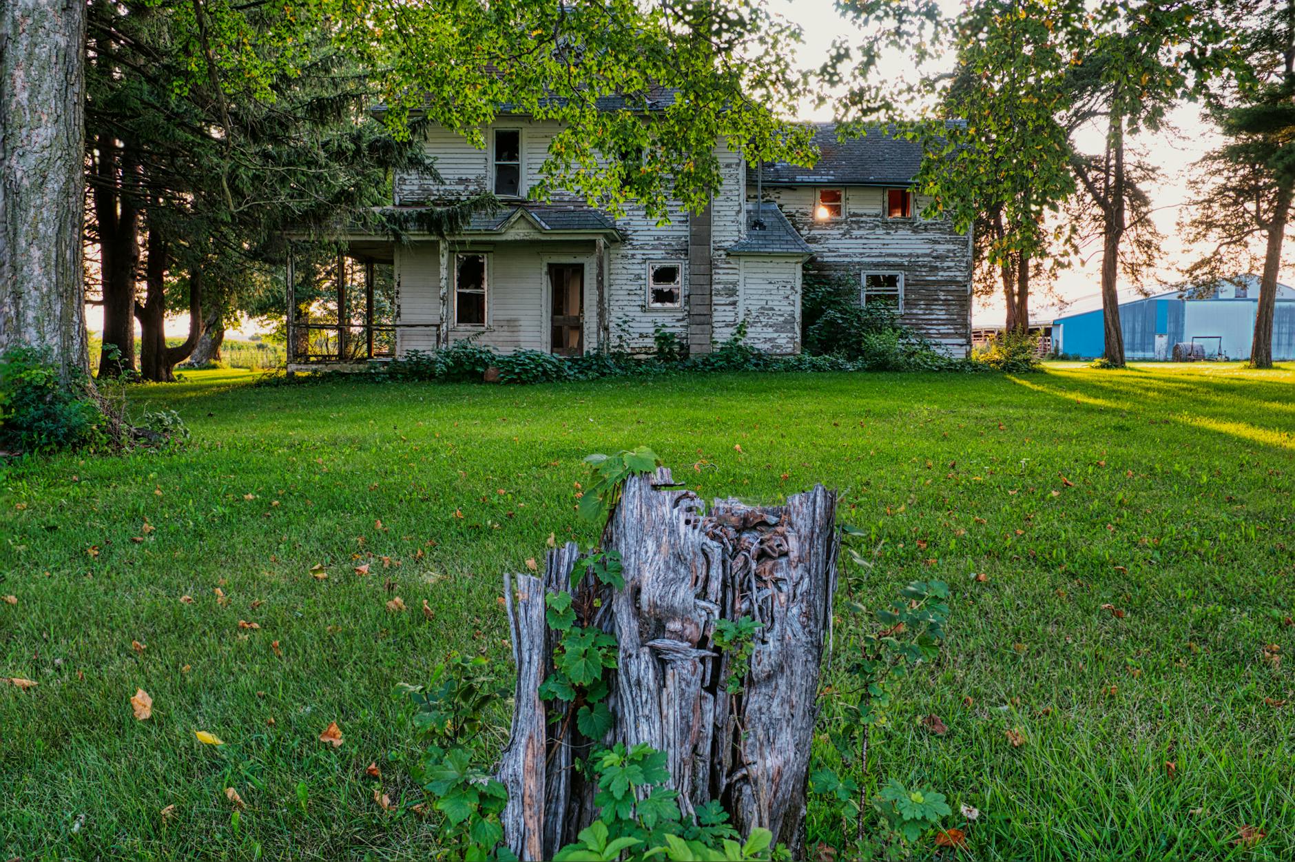 white and gray wooden house near green grass field